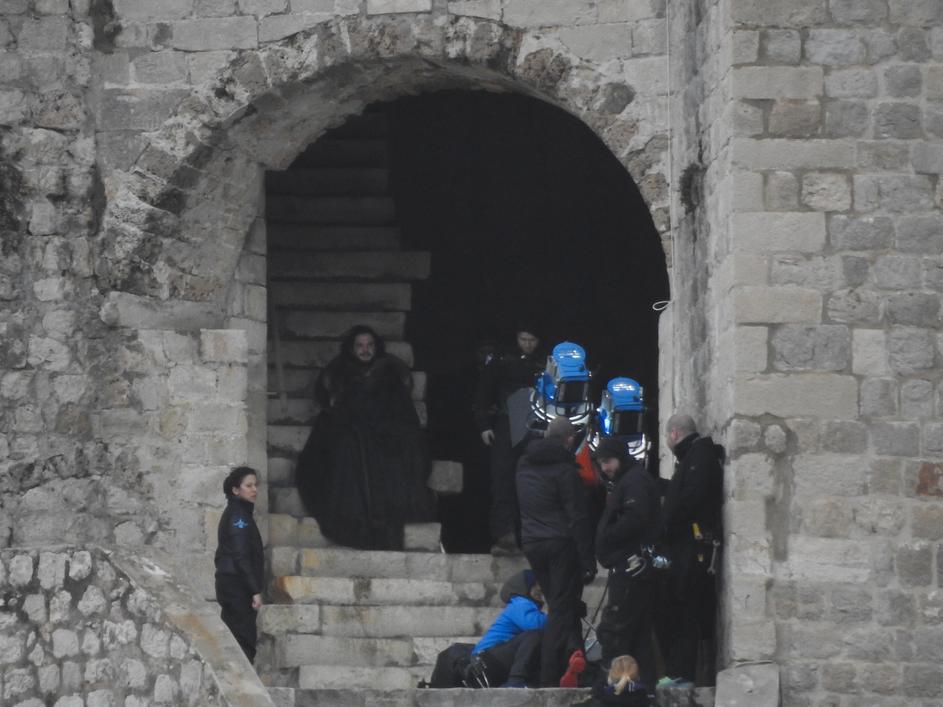 Jon Snow walks down the stairs of the tower, to the city walls