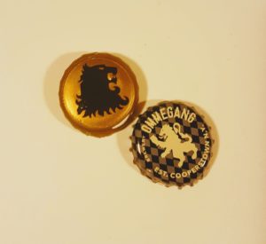 The Lannister lion foil and the Hand of the Queen's Ommegang bottlecap 